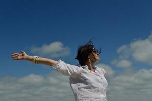 young woman with spreading arms to sky photo