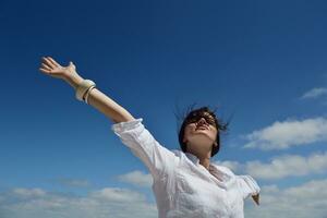 young woman with spreading arms to sky photo