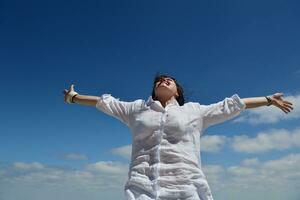 young woman with spreading arms to sky photo