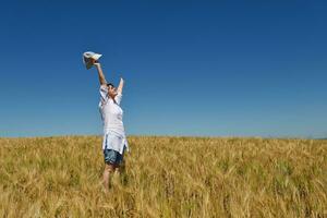 young woman in wheat field at summer photo