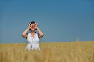 young woman in wheat field at summer photo