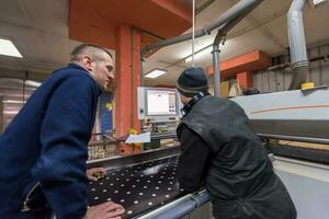 carpenters calculating and programming a cnc wood working machine photo