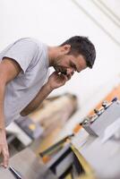 engineer in front of wood cutting machine photo