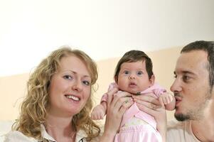 indoor portrait with happy young family and  cute little babby photo