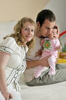 indoor portrait with happy young famil and  cute little babby photo