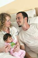 indoor portrait with happy young family and  cute little babby photo