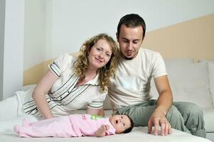 retrato interior con familia joven feliz y pequeño bebé lindo foto