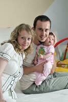 indoor portrait with happy young family and  cute little babby photo