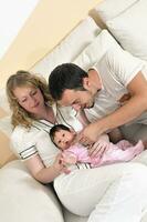 retrato interior con una familia joven feliz y un lindo bebé foto