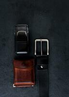 cinturón negro, billetera y perfume foto