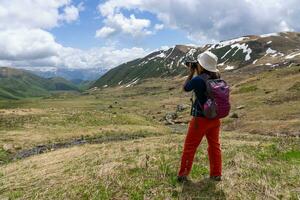 Trekker Using Camera to Shoot Photo of Beautiful Trail to Abudelauri Lakes Georgia in Summer