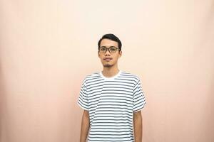 Asian man in glasses wearing casual striped t-shirt, standing pose, smiling and serious. photo