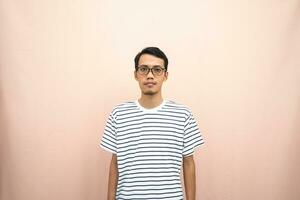 Asian man in glasses wearing casual striped t-shirt, standing pose, smiling and serious. photo