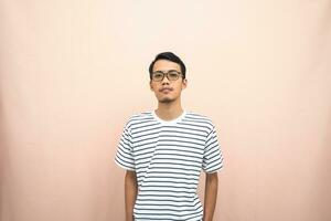 Asian man in glasses wearing casual striped t-shirt, standing pose, smiling and serious. photo
