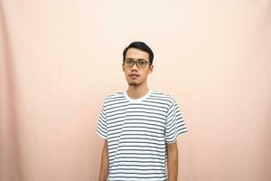 Asian man in glasses wearing casual striped t-shirt, standing pose, smiling and serious. photo