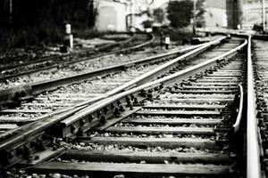 Lots of intersecting rails. Fastening to sleepers and bolting the rails together. Stylized black and white photo. Selective focus in the foreground. Blurred background. photo