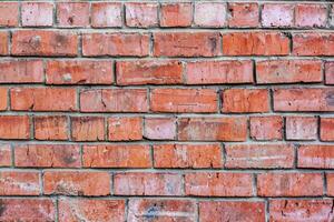 Red brick wall with very old and cracked stones. Mortar stained texture. photo