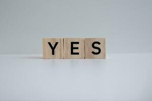 Wooden blocks form the text YES against a white background. photo