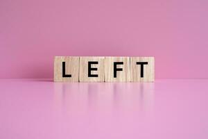 Wooden blocks form the text LEFT against a pink background. photo