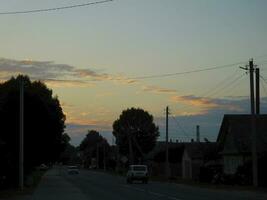 beautiful sky with clouds in the evening above the road with cars photo