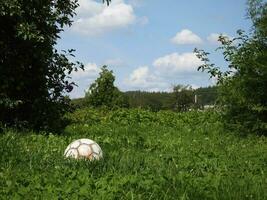 soccer ball is on the grass in the country photo