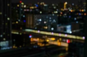 Bright glowing lights under dusk sky in evening on bokeh or blurred background of district nonthaburi in Thailand photo