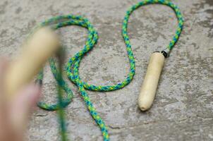 Jump rope on cement floor background, side view photo