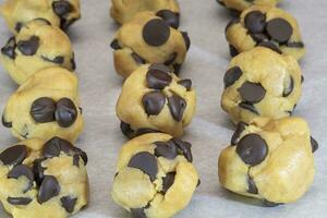 Balls of Chocolate Chip Cookie Dough with Extra Chips Ready for the Oven photo