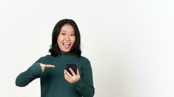 Holding Smartphone and Pointing to smartphone with smiling face Of Beautiful Asian Woman Isolated On White Background photo