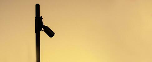 Silhouette of security camera on sunset,banner photo