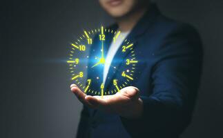 Businessman showing a virtual clock in his hand. Concept of saving time, overtime OT, work hours of employees in organization, and Efficient work schedule management photo