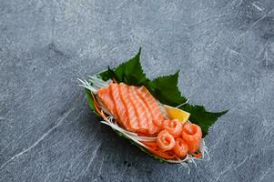 Fresco salmón sashimi con hierbas y limón para japonés menú foto