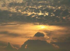 el sol sale y se pone por la mañana y por la noche y los árboles están sombreados de negro, cielo anaranjado y nubes. cálido, romántico y gloriosamente hermoso, se ve cálido y viajero. foto