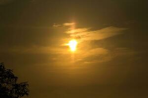 el sol sale y se pone por la mañana y por la noche y los árboles están sombreados de negro, cielo anaranjado y nubes. cálido, romántico y gloriosamente hermoso, se ve cálido y viajero. foto