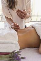 Woman lying on stretcher receiving ayurvedic massage with organic oil. photo