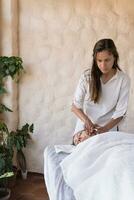 mujer recepción facial masaje en spa por joven terapeuta. foto