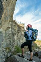 Female climber standing in front of rock. photo