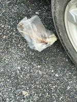 a closeup of a junk in a white bag on the street photo