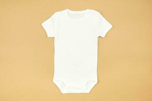 White baby girl or boy bodysuit mockup flat lay on craft paper background. Design onesie template, print presentation mock up. Top view. photo