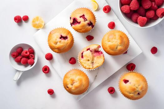 Raspberry muffins with fresh raspberries on a white table, close up, light background. Top view. A delicious dessert or breakfast. AI generated. photo