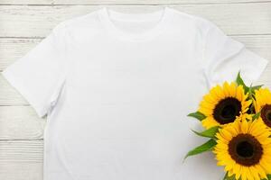 White womens cotton T Shirt mockup with sunflowers on white wooden background. Design t shirt template, print presentation mock up. Top view flat lay. photo