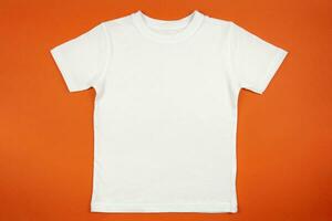 White womens cotton tshirt mockup on orange background. Design t shirt template, print presentation mock up. Top view flat lay. photo