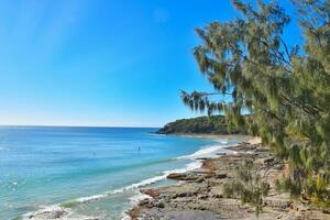 Noosa national park,The beach and mountains are made up of nature, with the sun shining on the surface of the sea. photo