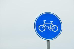 bicicleta firmar en el la carretera en un claro cielo fondo, sin nubes, gradiente cielo, tráfico firmar en transparente antecedentes. foto