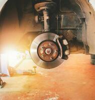 Dto frenos y calibrador ese eliminar el ruedas de un coche en el auto reparar garaje con luz de sol. foto