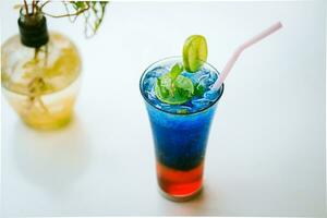 Blue Lagoon mojito-A mocktail drink which is soda and blue in colour served with ice cubes photo