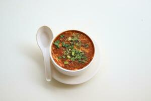 hecho en casa tomate sopa en un blanco cuenco con platillo. lado ver aislado en un blanco antecedentes. foto