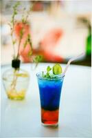 Blue Lagoon mojito-A mocktail drink which is soda and blue in colour served with ice cubes photo