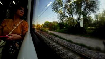 jovem mulher viajando em uma trem durante a dia olhando Fora a janela video