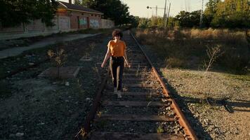 joven mujer caminando en abandonado muerto tren pistas video